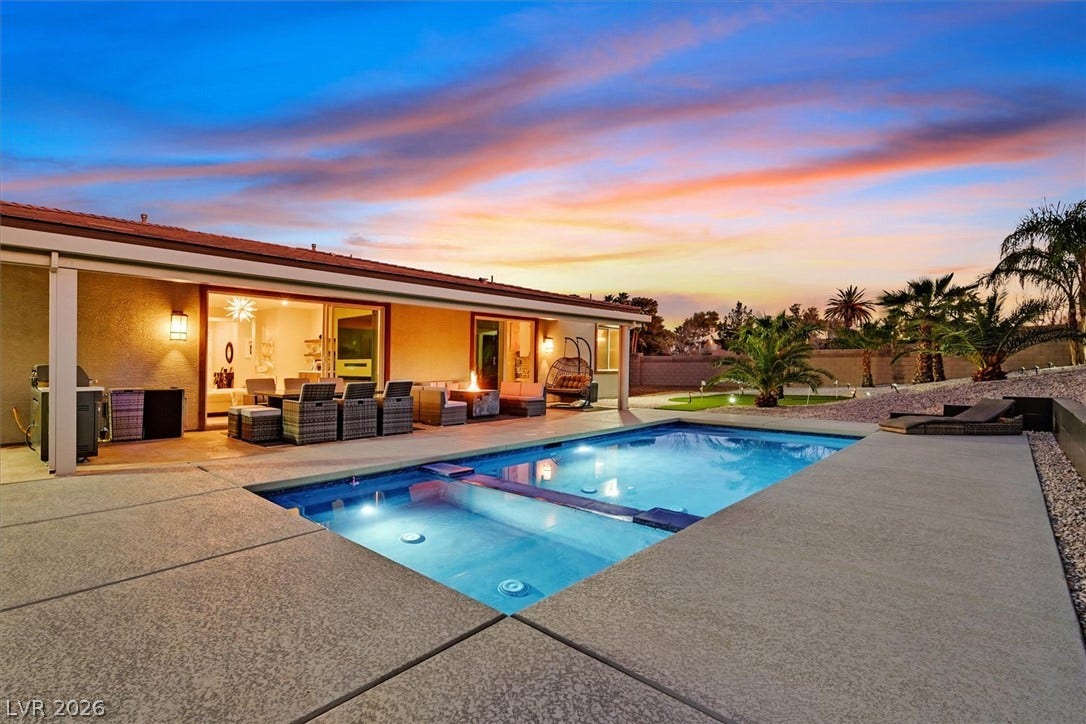 2689 Pioneer Estates Court, Las Vegas, NV 89117 An inviting backyard oasis features a pristine swimming pool and concrete patio beneath a sunset sky.