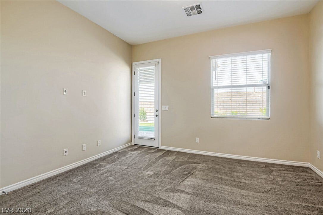 647 Longfeather Street, Henderson, NV 89011 An inviting glass-paneled door leads outside from this carpeted bedroom with tall ceilings.