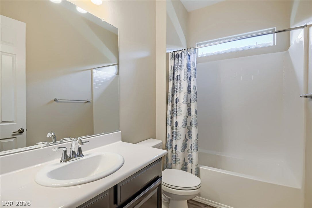 647 Longfeather Street, Henderson, NV 89011 High ceilings and a transom window bring natural light into this functional full bathroom.