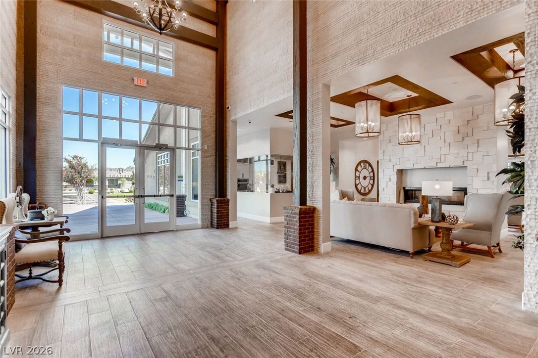 647 Longfeather Street, Henderson, NV 89011 Double-height ceilings and a dramatic stone fireplace welcome arrivals in this impressive foyer.