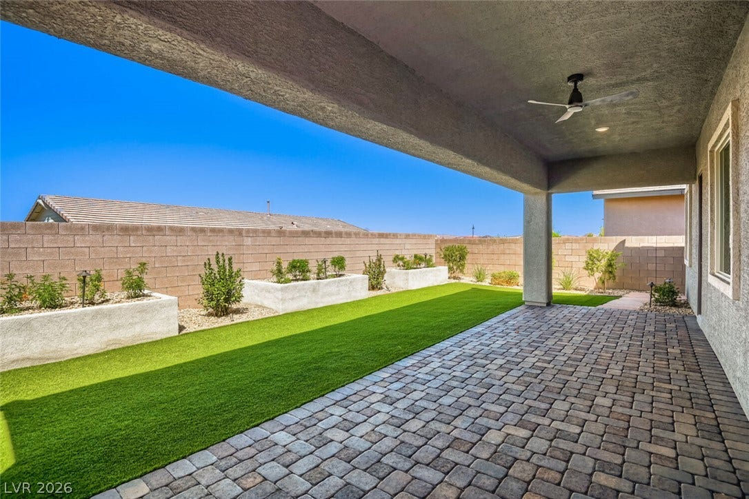 647 Longfeather Street, Henderson, NV 89011 A covered paver patio overlooks a tidy yard enclosed by masonry walls.