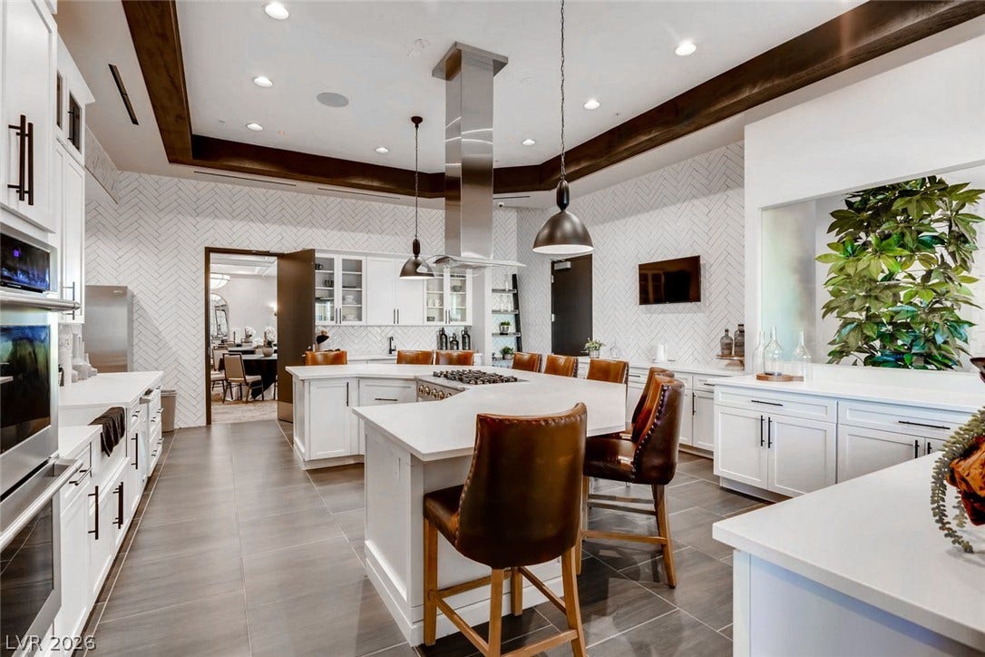 647 Longfeather Street, Henderson, NV 89011 Rich wood trim borders the ceiling above a gourmet island kitchen with herringbone tile walls.