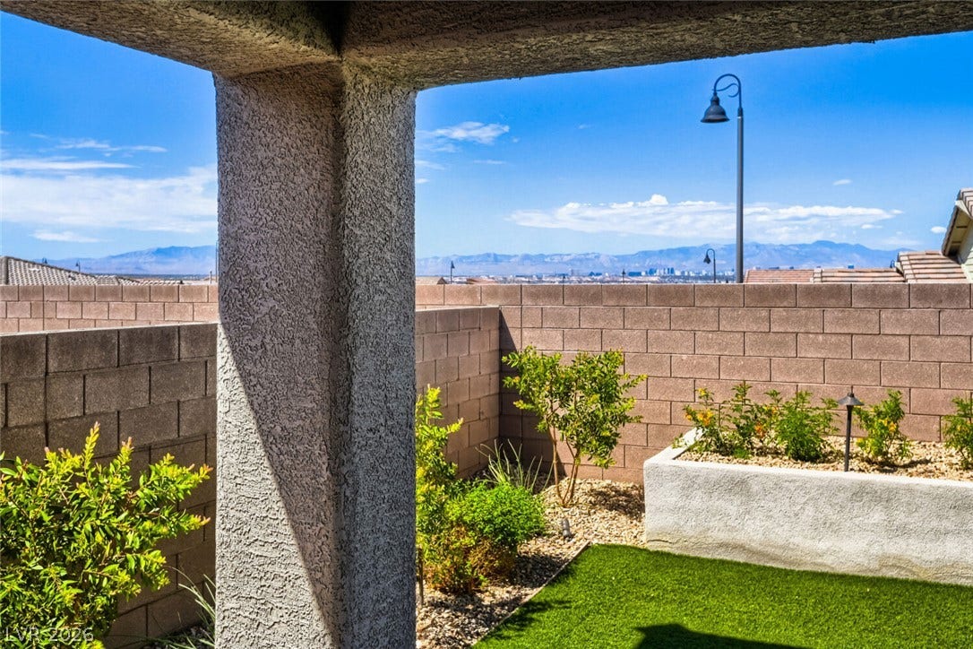 647 Longfeather Street, Henderson, NV 89011 Distant mountain views frame this private backyard retreat featuring low-maintenance landscaping and a covered patio area.