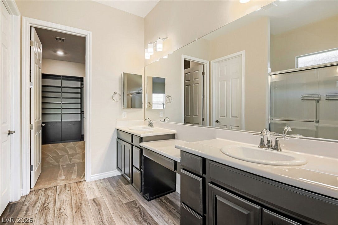 647 Longfeather Street, Henderson, NV 89011 A spacious vanity area with dual sinks connects directly to a large walk-in closet.