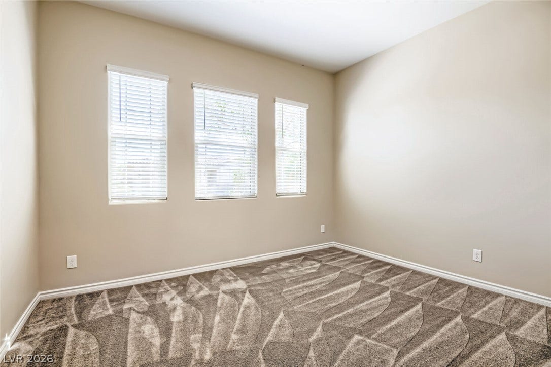 647 Longfeather Street, Henderson, NV 89011 Plush carpeting and three tall windows define this versatile secondary bedroom space.