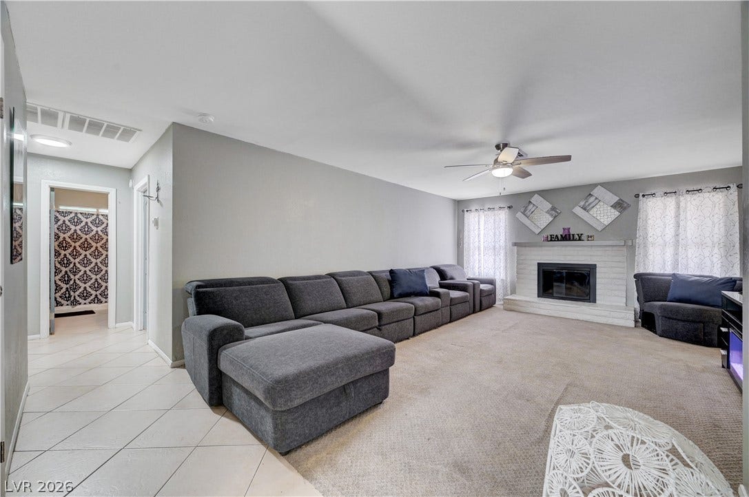 2829 N Michael Way, Las Vegas, NV 89108 A classic brick fireplace anchors this spacious living area featuring tiled and carpeted flooring.
