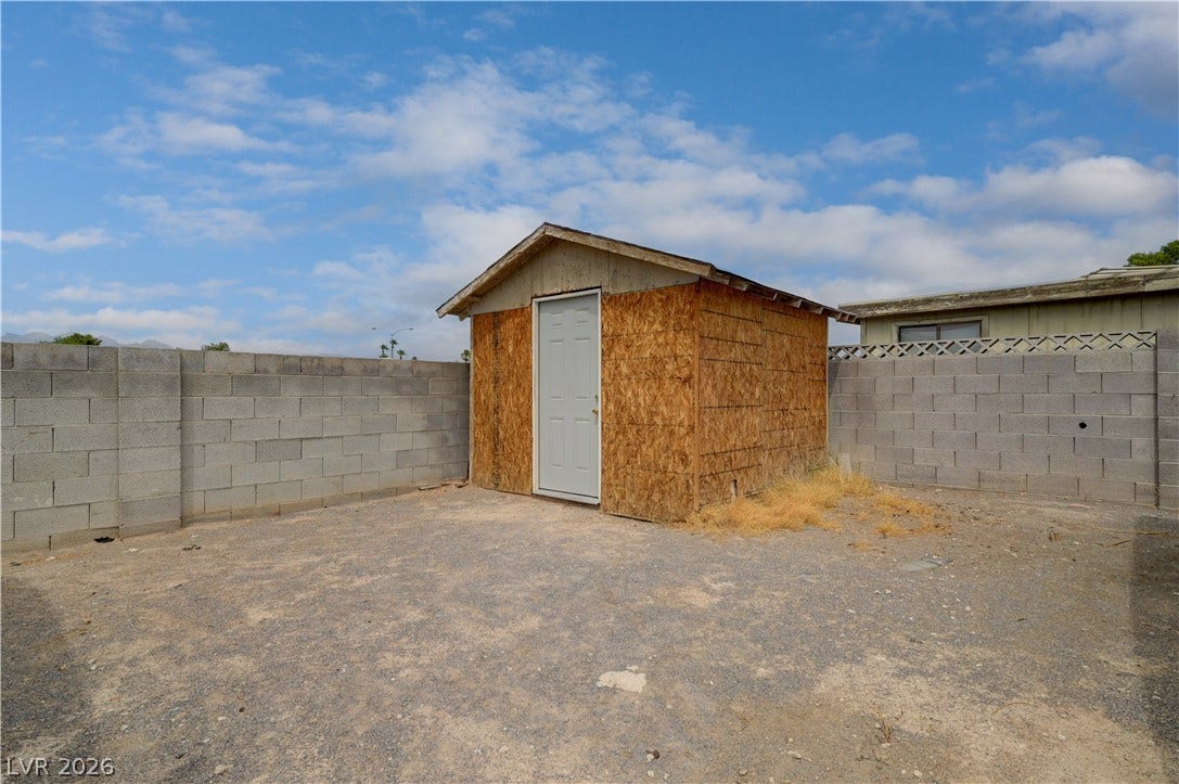 2829 N Michael Way, Las Vegas, NV 89108 A spacious backyard area features concrete block fencing and a detached wooden storage shed.