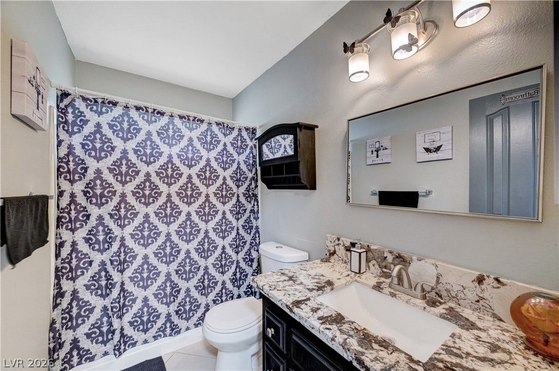 2829 N Michael Way, Las Vegas, NV 89108 Richly patterned stone counters elevate this modern vanity setup.