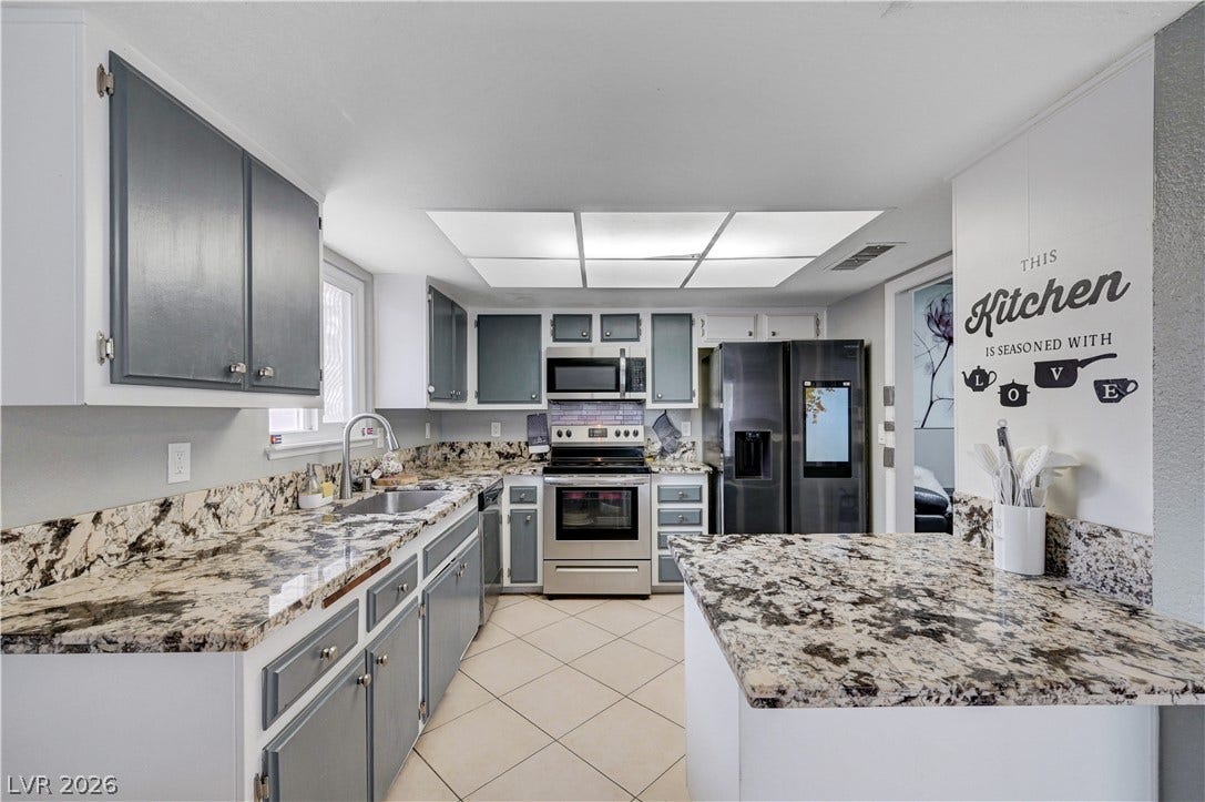 2829 N Michael Way, Las Vegas, NV 89108 Gleaming granite countertops anchor this functional workspace featuring clean tile flooring.