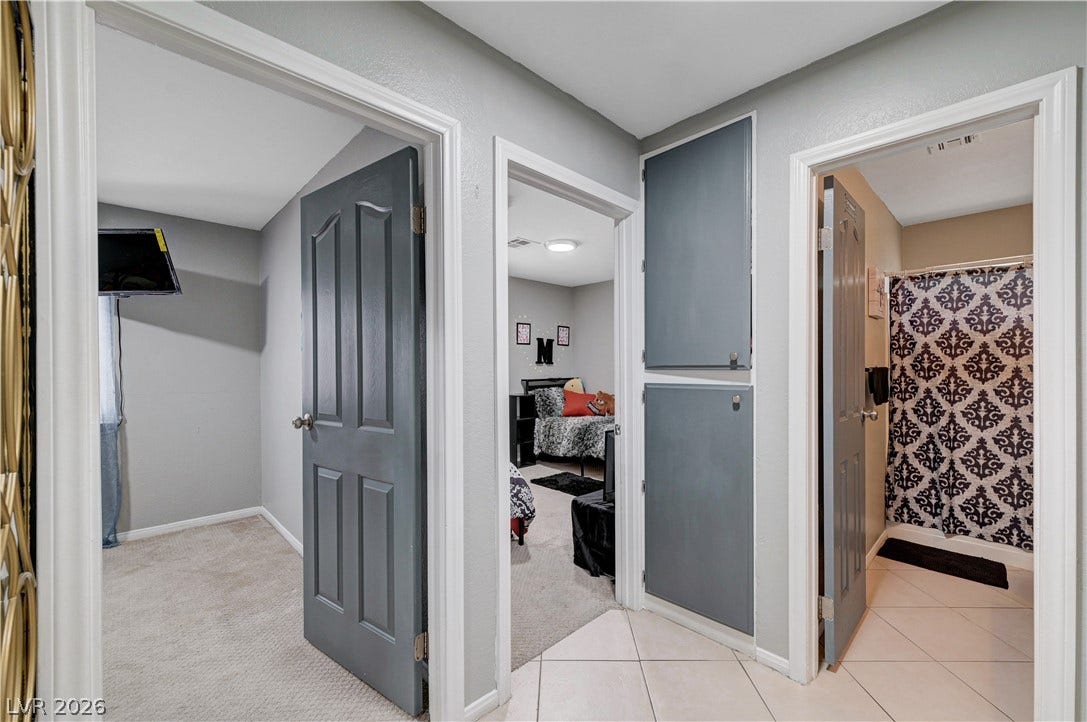 2829 N Michael Way, Las Vegas, NV 89108 A functional hallway connects multiple rooms featuring tile and carpet flooring with classic crown molding accents.