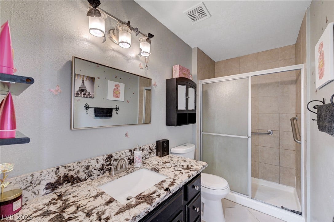 2829 N Michael Way, Las Vegas, NV 89108 An elegant granite countertop accents the vanity in this modern guest bathroom.