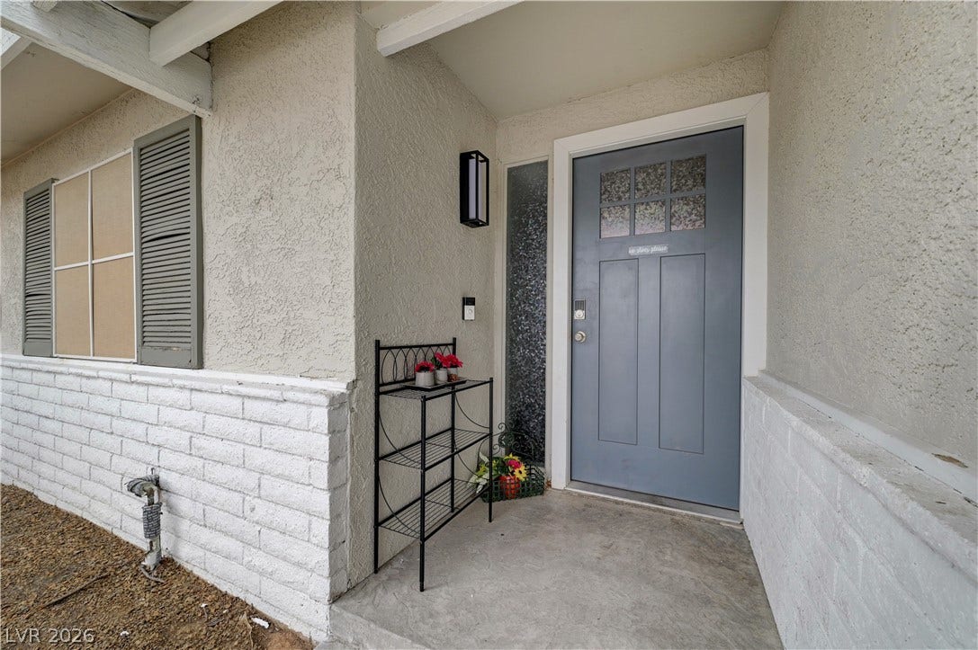 2829 N Michael Way, Las Vegas, NV 89108 Welcoming entryway showcases a handsome front door, textured stucco siding, and classic brick detailing.