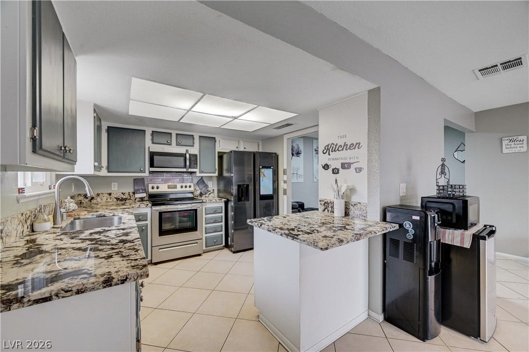 2829 N Michael Way, Las Vegas, NV 89108 Polished stone countertops pair elegantly with tile flooring in this modern, functional kitchen.
