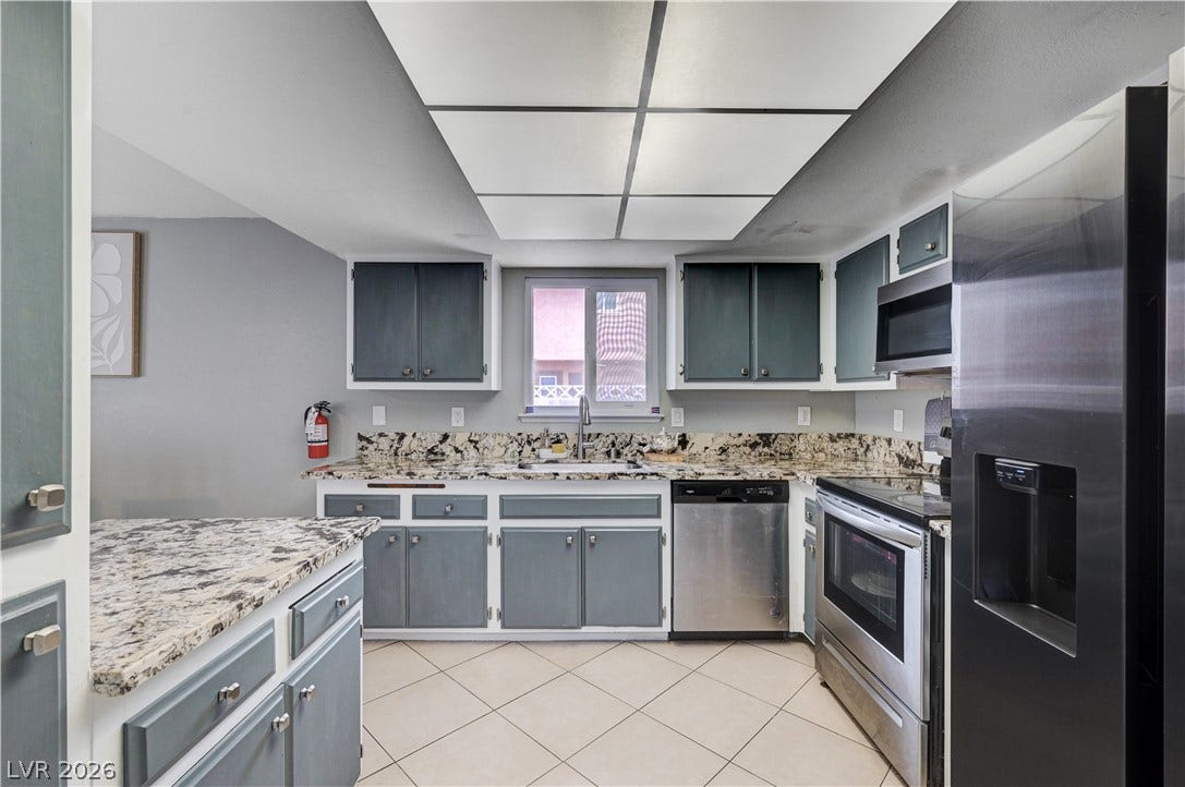 2829 N Michael Way, Las Vegas, NV 89108 Striking granite countertops pair beautifully with painted cabinetry and tile flooring in this kitchen.