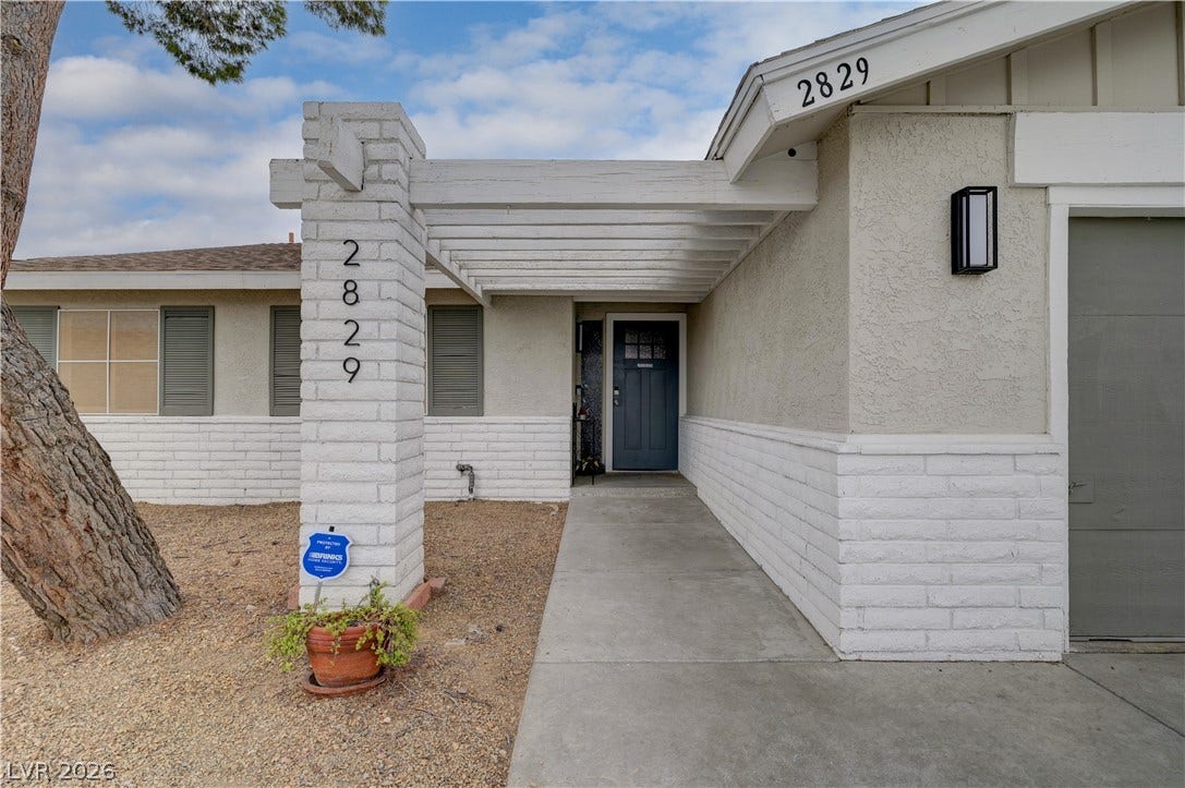 2829 N Michael Way, Las Vegas, NV 89108 An inviting concrete walkway leads past a brick pillar to the covered front entrance.