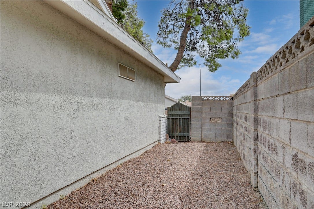 2829 N Michael Way, Las Vegas, NV 89108 A private, gravel-lined side yard is secured by a block wall and gated entry.