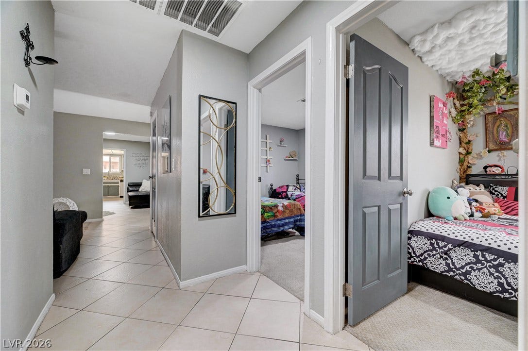 2829 N Michael Way, Las Vegas, NV 89108 A central tiled hallway connects multiple bedrooms and living spaces.