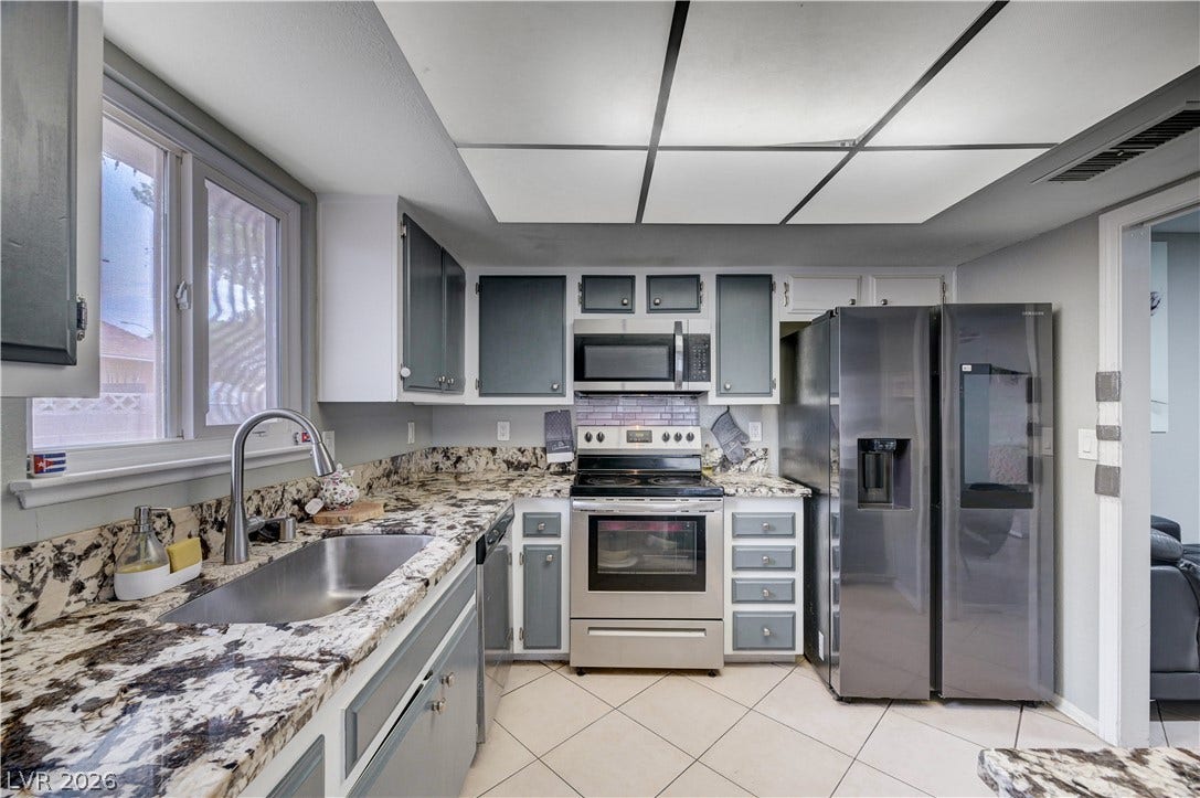 2829 N Michael Way, Las Vegas, NV 89108 Gleaming granite countertops pair beautifully with stainless steel appliances in this functional workspace.