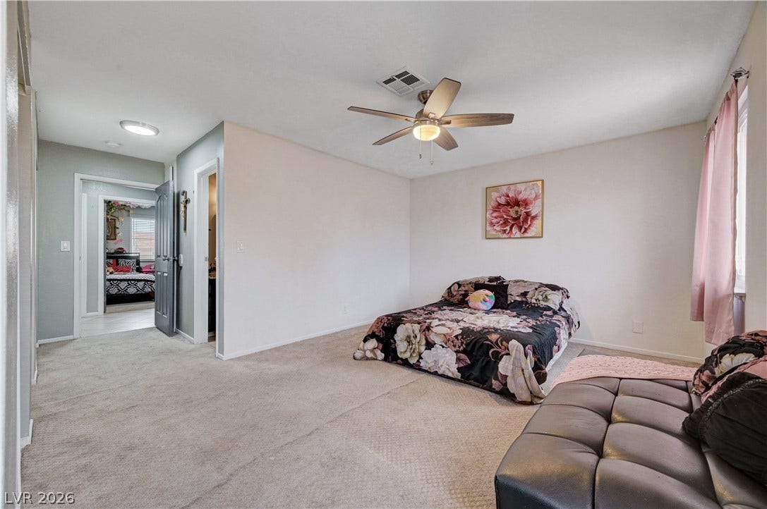 2829 N Michael Way, Las Vegas, NV 89108 A spacious bedroom boasts neutral carpeting and a wide doorway leading to adjacent living areas.
