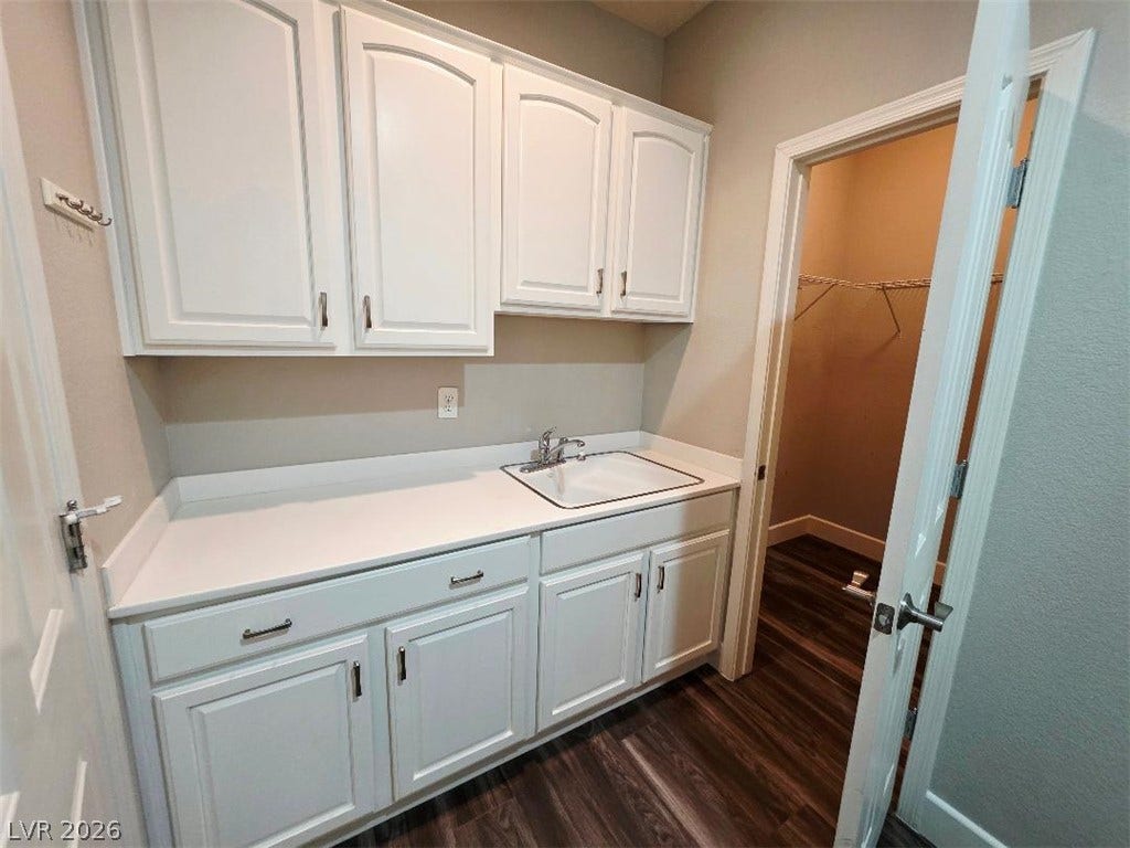 2237 Merrimack Valley Avenue, Henderson, NV 89044 A functional utility space highlights clean cabinetry, a built-in sink, and durable tile-flooring. with an extra room for storage