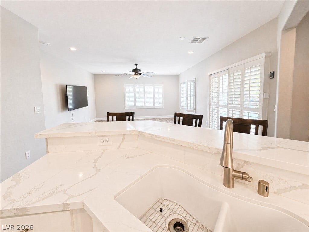 2237 Merrimack Valley Avenue, Henderson, NV 89044 Elegant quarts countertops and a modern sink anchor this seamless open-concept living space to living room