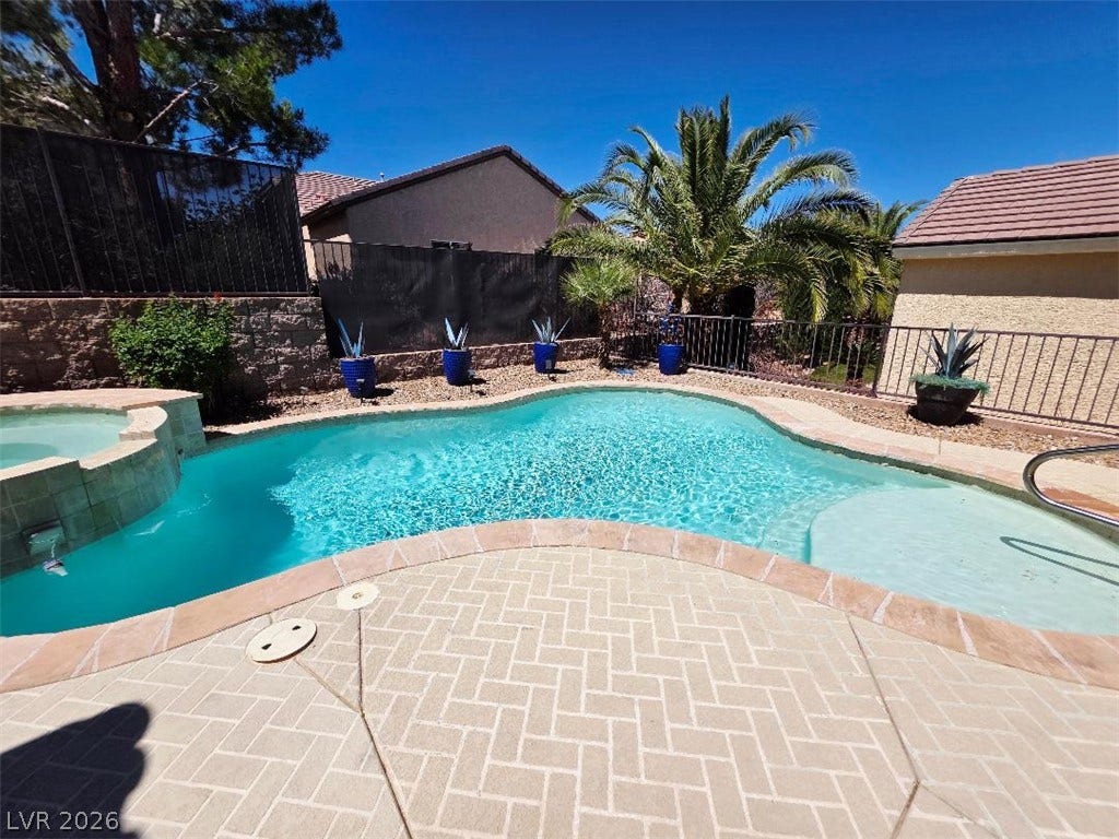 2237 Merrimack Valley Avenue, Henderson, NV 89044 An inviting backyard oasis features a sparkling custom heated pool alongside a coordinating spa.