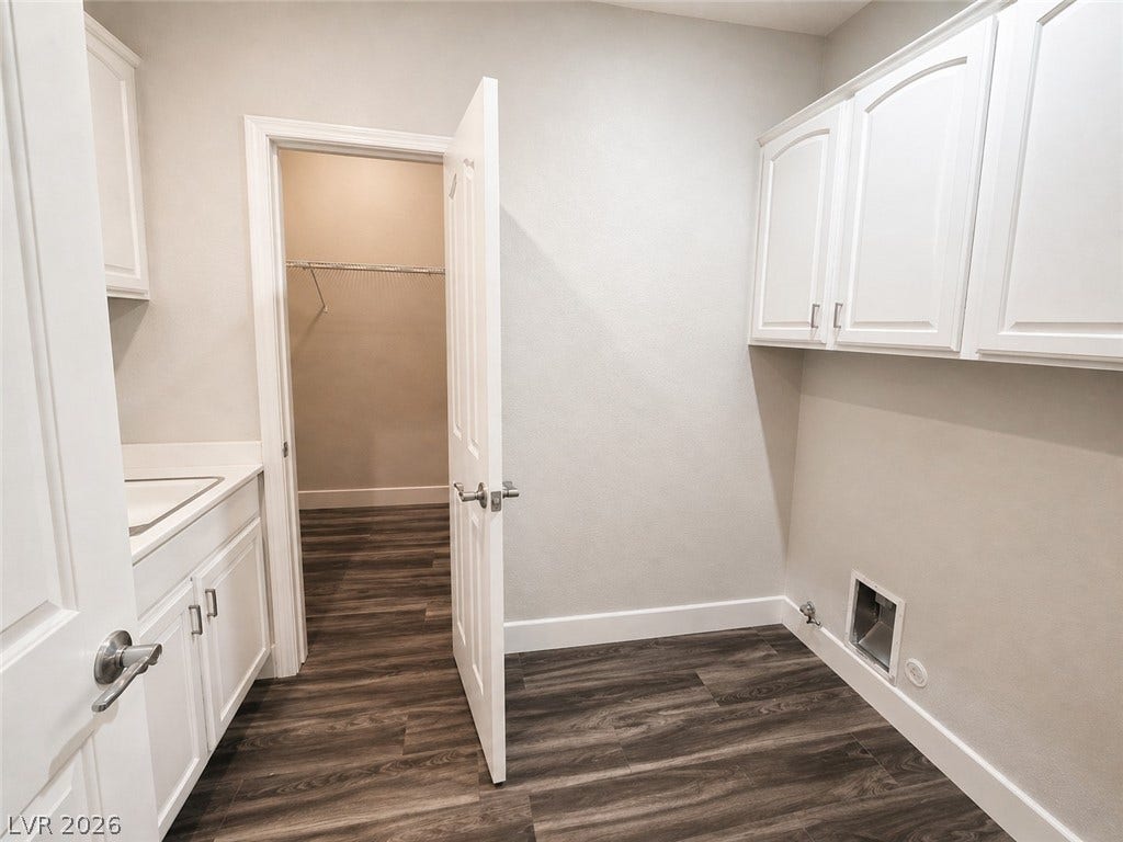 2237 Merrimack Valley Avenue, Henderson, NV 89044 A functional laundry area displays tile -flooring alongside white cabinetry and an adjacent walk-in closet.