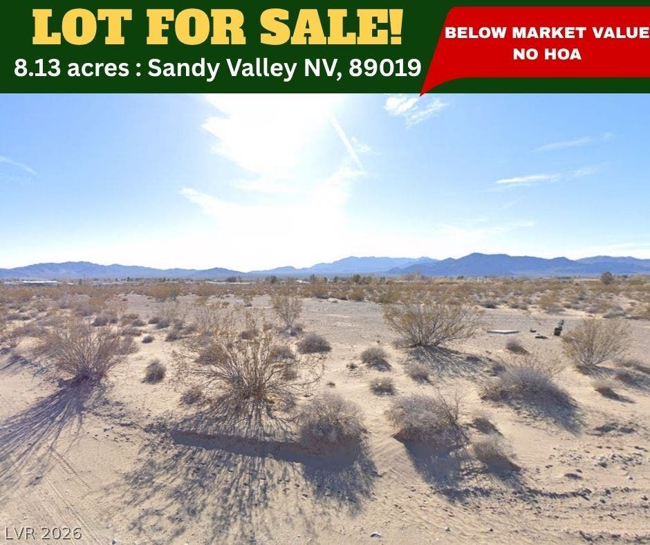 Panoramic mountain views surround this expansive desert parcel under clear blue skies.