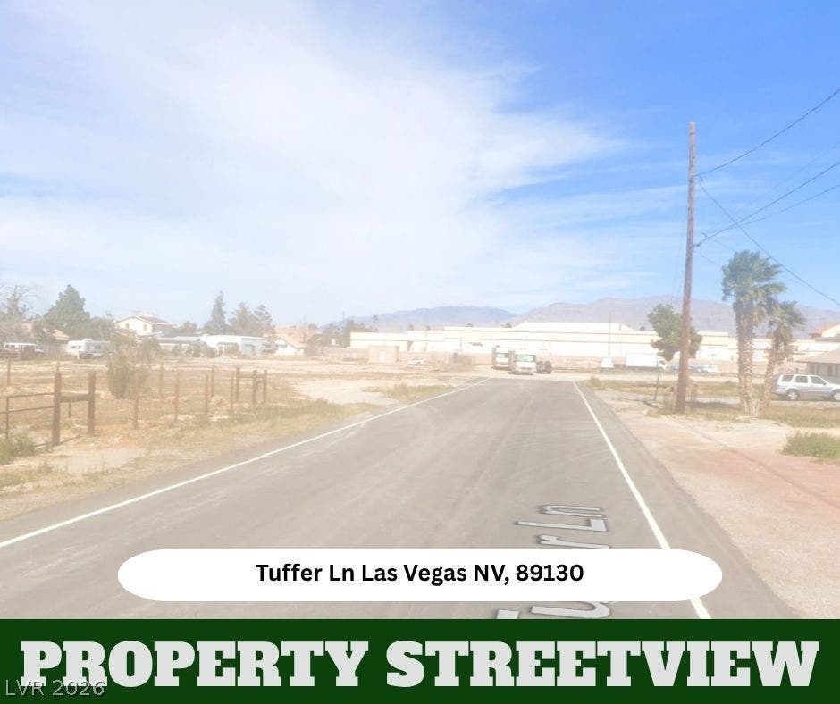 Mountain horizons overlook the quiet neighborhood street leading to this vacant property lot.