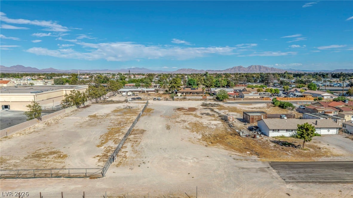 Distant mountains frame this vast parcel of land ready for development under blue skies.