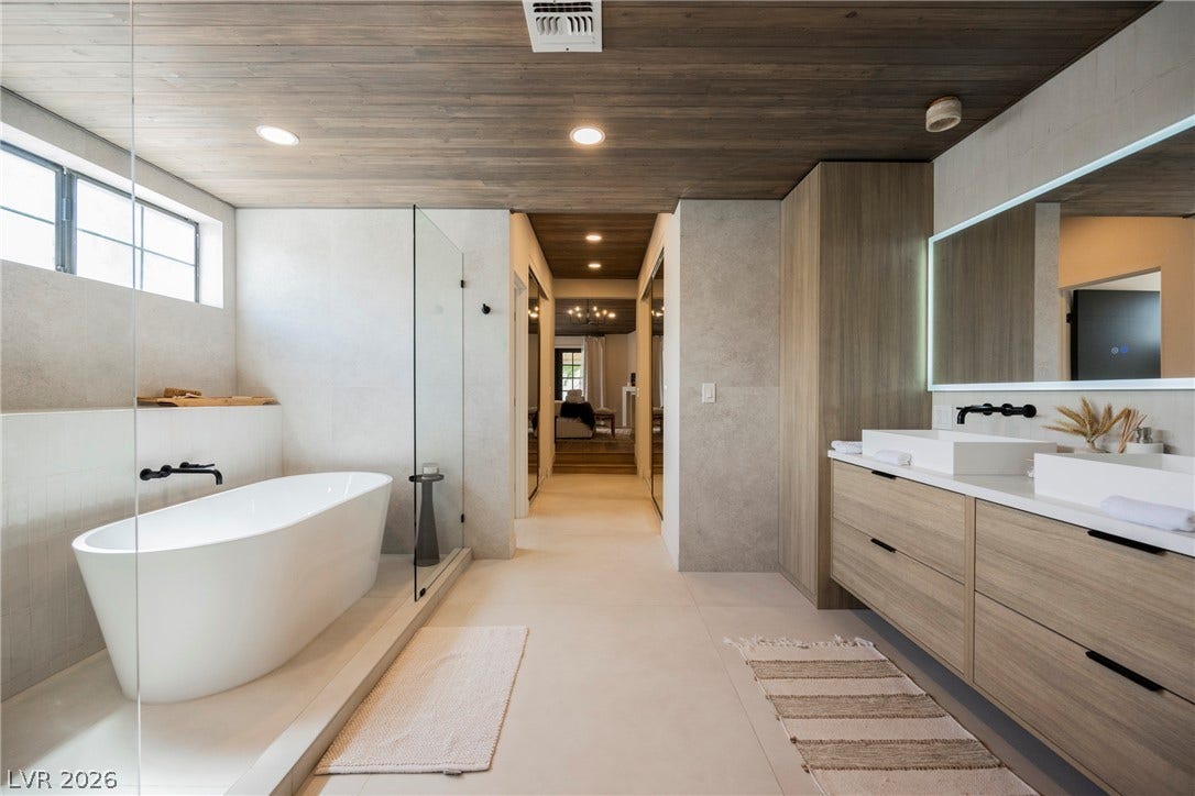 5741 S Pearl Street, Las Vegas, NV 89120 Warm wood ceilings and sleek stone surfaces define this contemporary primary bath oasis.