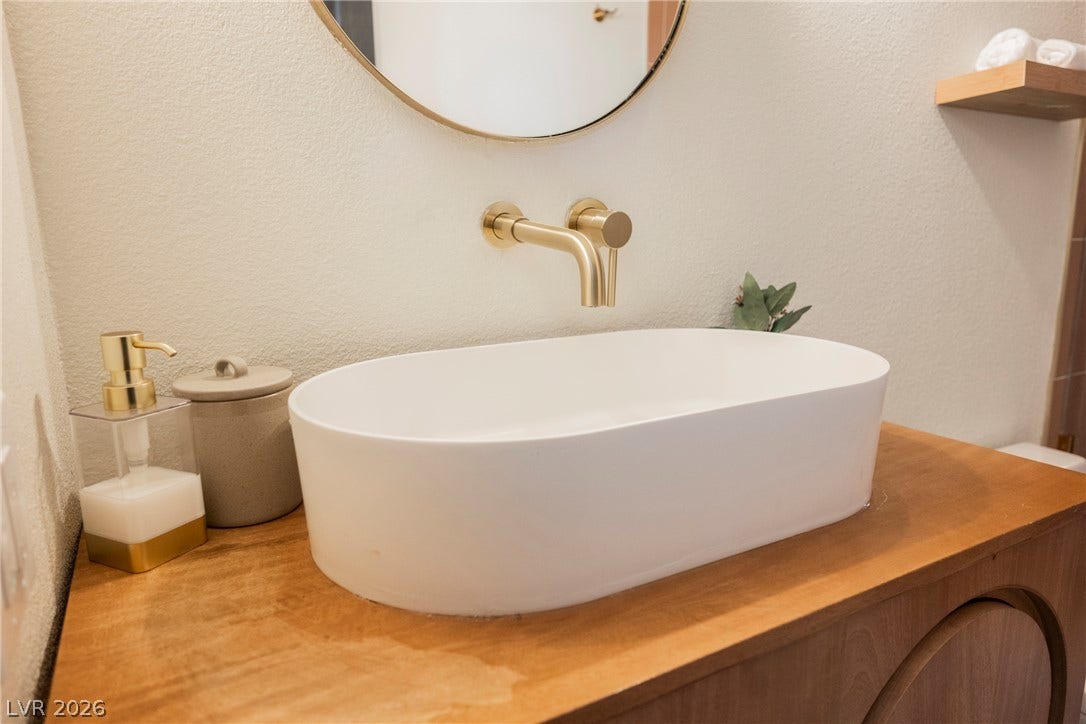 5741 S Pearl Street, Las Vegas, NV 89120 A modern vessel sink pairs elegantly with a wall-mounted brass faucet.