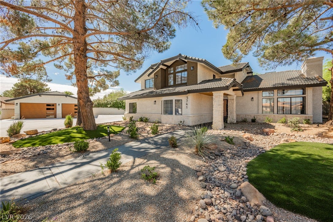 5741 S Pearl Street, Las Vegas, NV 89120 Mature trees frame a welcoming paved path leading to this elegant multi-level home.