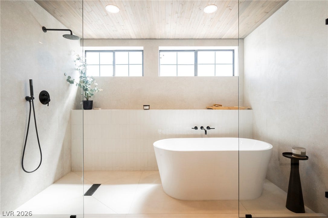 5741 S Pearl Street, Las Vegas, NV 89120 Natural wood ceilings and crisp tiling surround a freestanding soaking tub and glass shower.