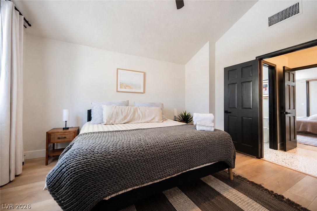 5741 S Pearl Street, Las Vegas, NV 89120 Vaulted ceilings and wide-plank wood floors create an airy atmosphere in this inviting bedroom.