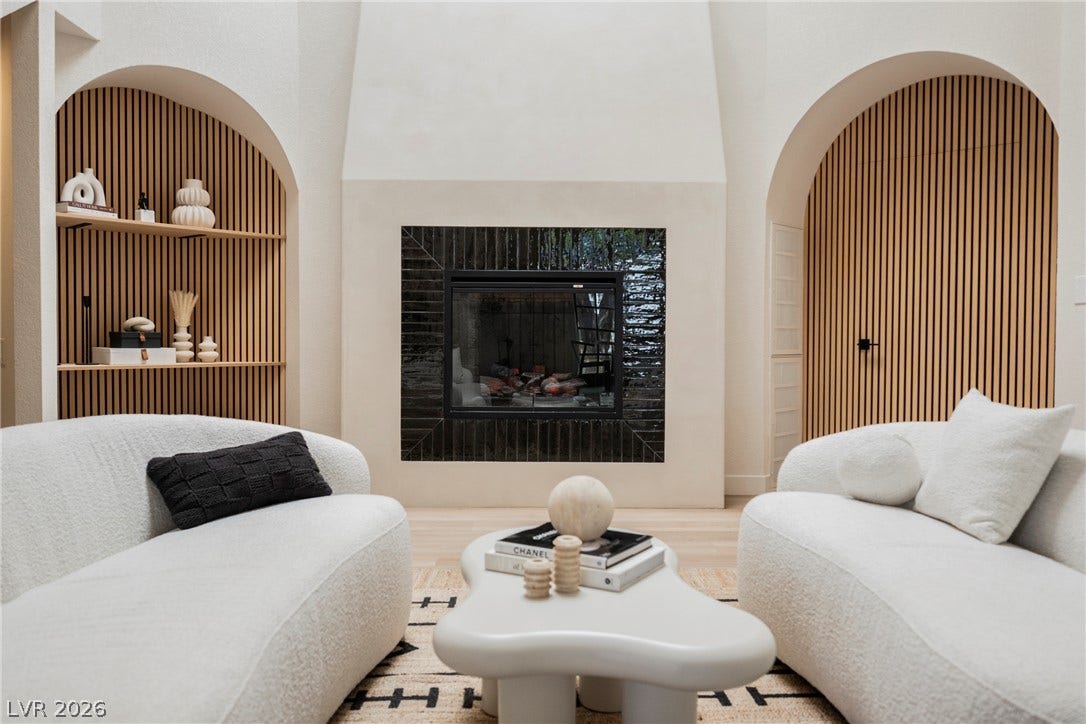 5741 S Pearl Street, Las Vegas, NV 89120 Arched architectural details frame a modern tiled fireplace and light hardwood flooring.