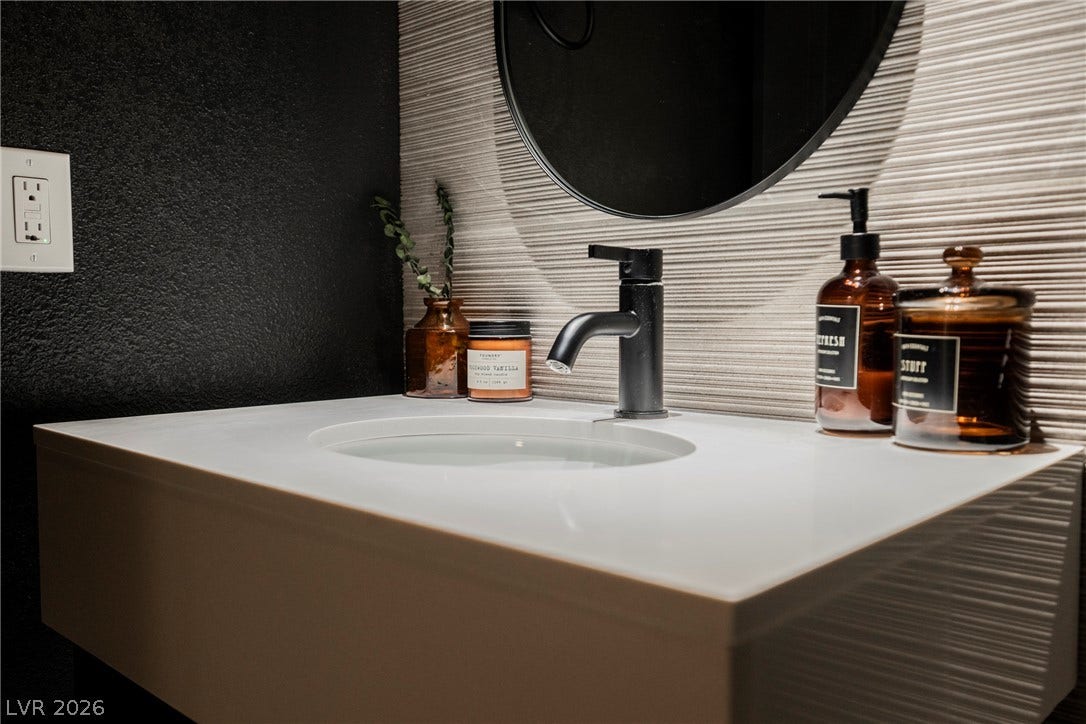 5741 S Pearl Street, Las Vegas, NV 89120 Modern textured wall detailing pairs perfectly with a sleek floating vanity and matte black faucet.