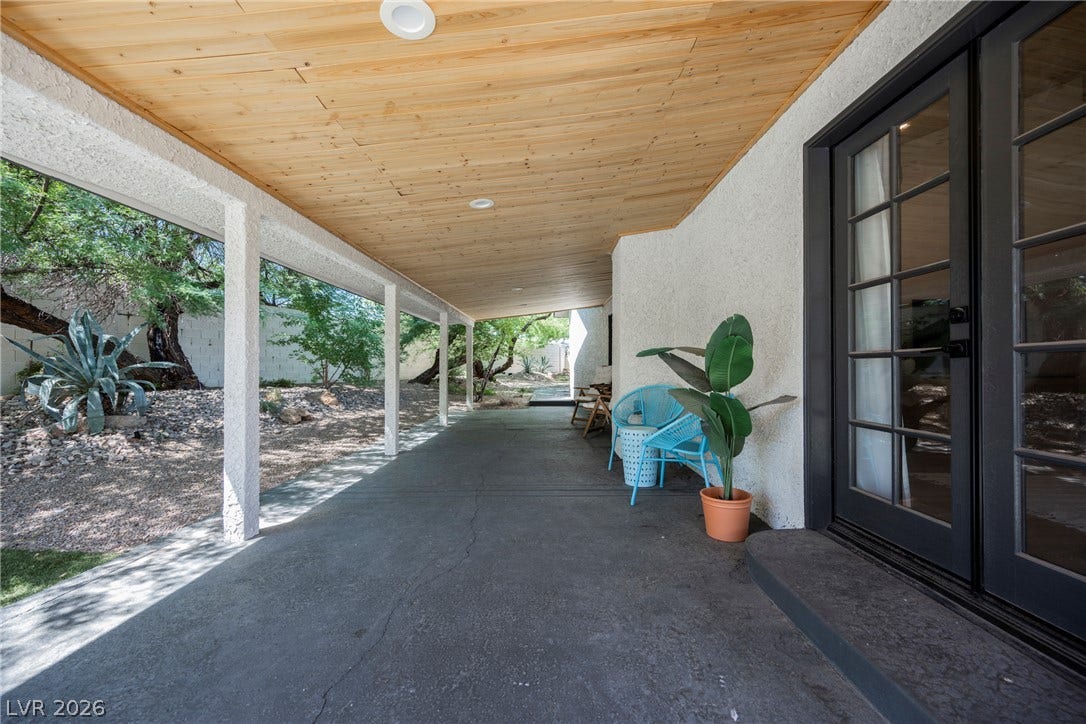 5741 S Pearl Street, Las Vegas, NV 89120 A long covered patio features concrete flooring and a warm wood plank ceiling with recessed lighting.