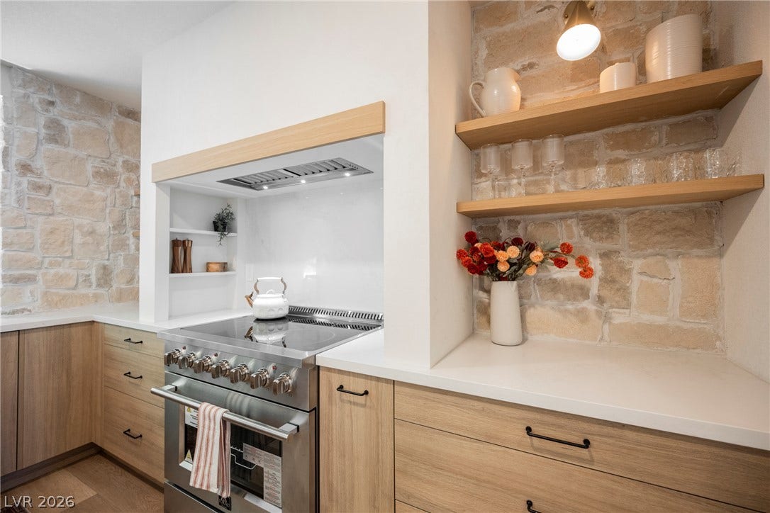 5741 S Pearl Street, Las Vegas, NV 89120 Natural stone accent walls pair beautifully with warm wood cabinetry and modern solid-surface countertops.