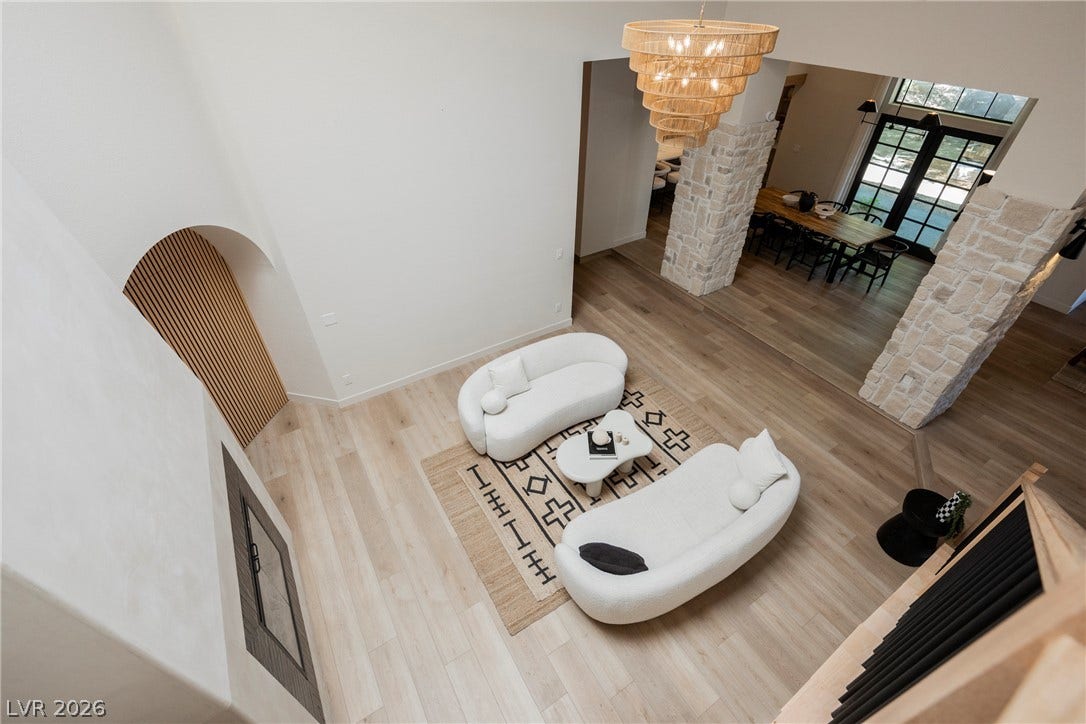 5741 S Pearl Street, Las Vegas, NV 89120 Soaring ceilings and light wood floors define this airy living space with stone columns.