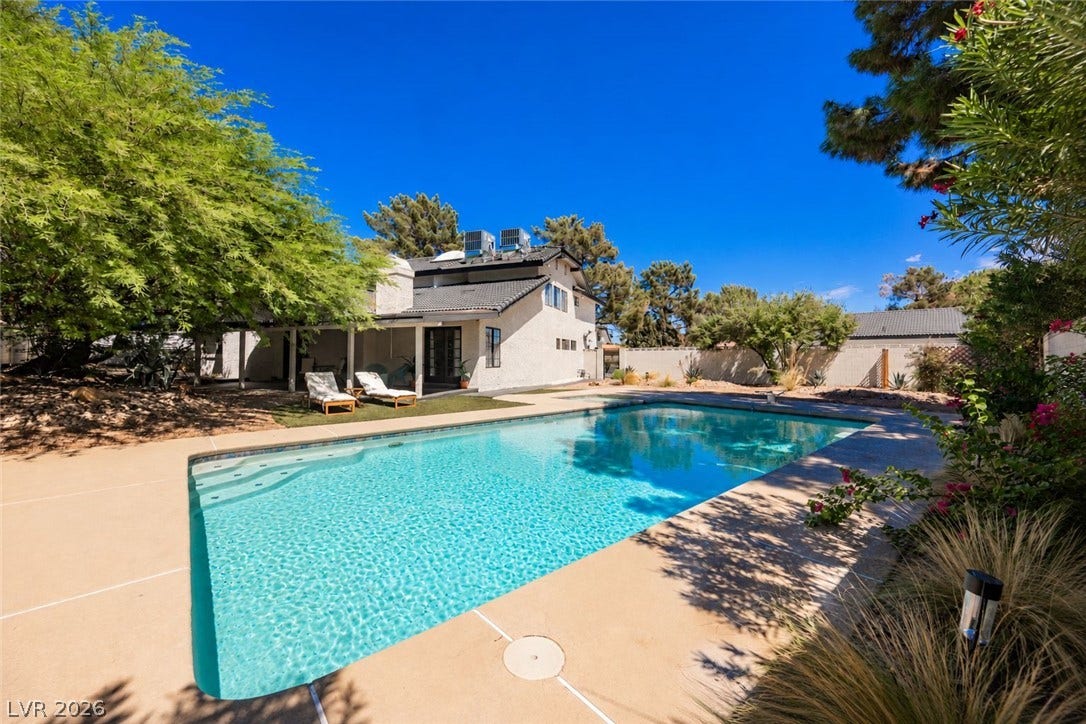 5741 S Pearl Street, Las Vegas, NV 89120 An inviting backyard oasis features a sparkling swimming pool under clear blue skies.