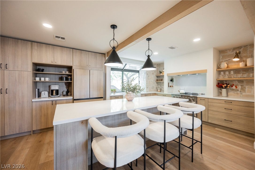 5741 S Pearl Street, Las Vegas, NV 89120 Natural wood cabinetry and a central stone-topped island define this modern culinary space.