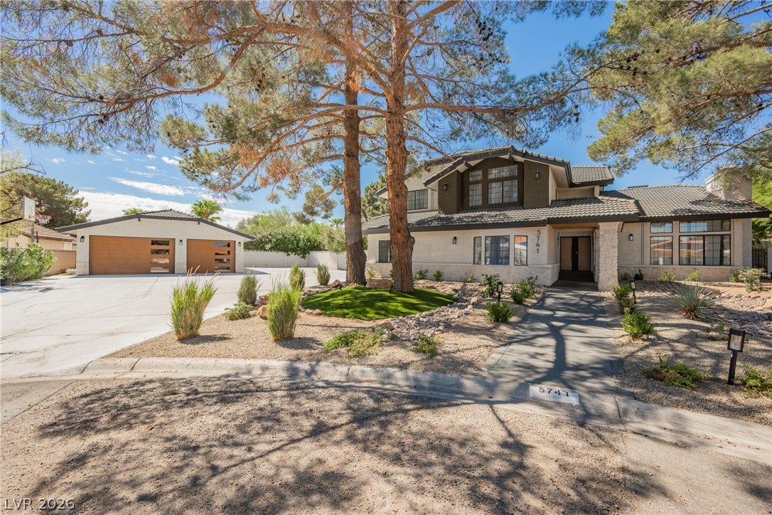 5741 S Pearl Street, Las Vegas, NV 89120 Mature trees shade the front walkway leading to this two-story desert residence.