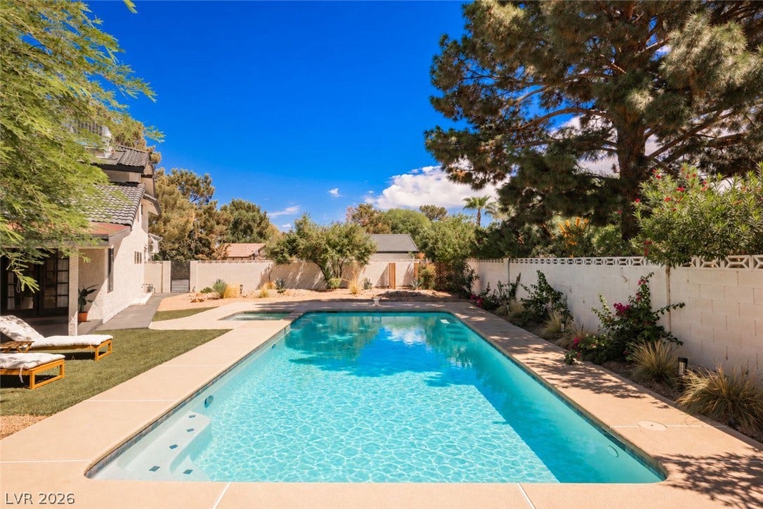 5741 S Pearl Street, Las Vegas, NV 89120 An inviting swimming pool centers this walled backyard, framed by mature trees and paved decking.