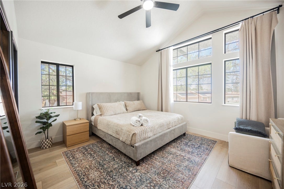 5741 S Pearl Street, Las Vegas, NV 89120 Vaulted ceilings and wide plank flooring elevate this serene, light-filled bedroom design.