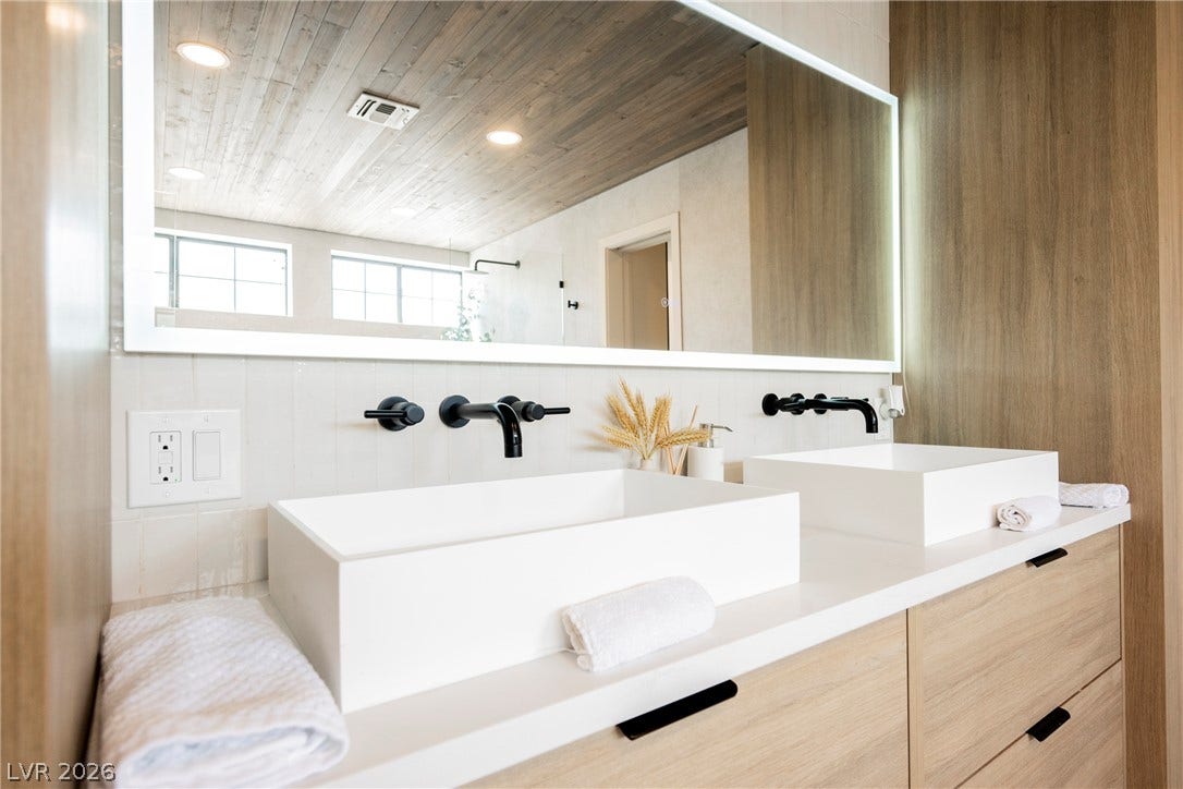 5741 S Pearl Street, Las Vegas, NV 89120 Clean lines and warm wood accents define this modern bathroom vanity area.