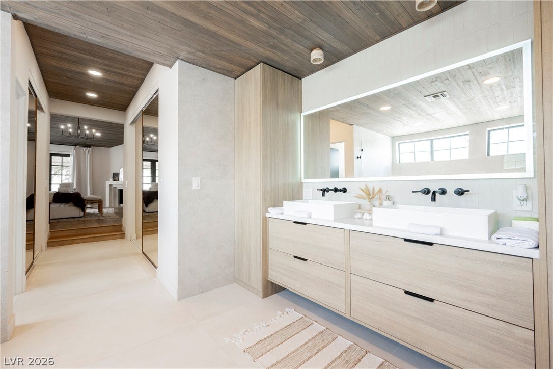 5741 S Pearl Street, Las Vegas, NV 89120 A wooden ceiling and sleek dual vanity elevate this modern primary bath design.