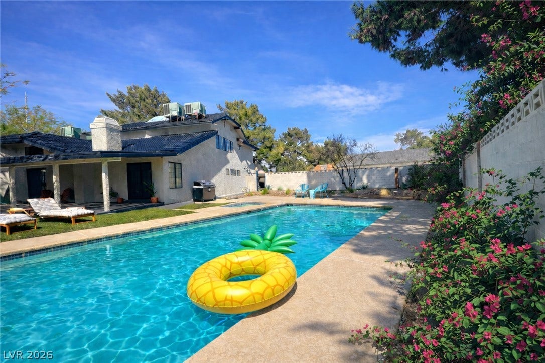5741 S Pearl Street, Las Vegas, NV 89120 An inviting backyard oasis features a sparkling swimming pool alongside a covered rear patio.