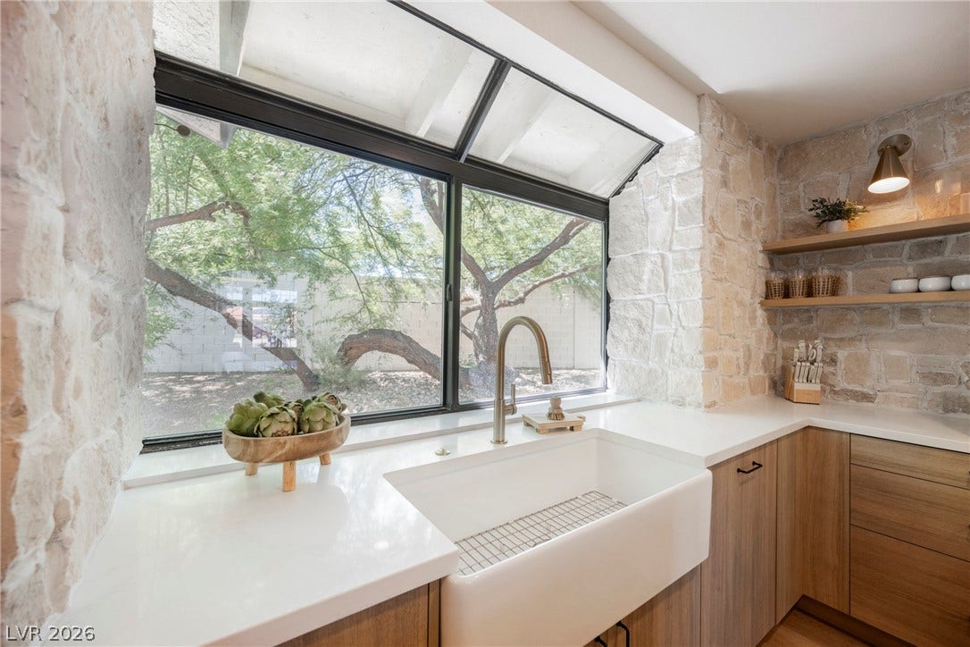 5741 S Pearl Street, Las Vegas, NV 89120 Natural stone walls frame a garden window overlooking lush outdoor greenery.