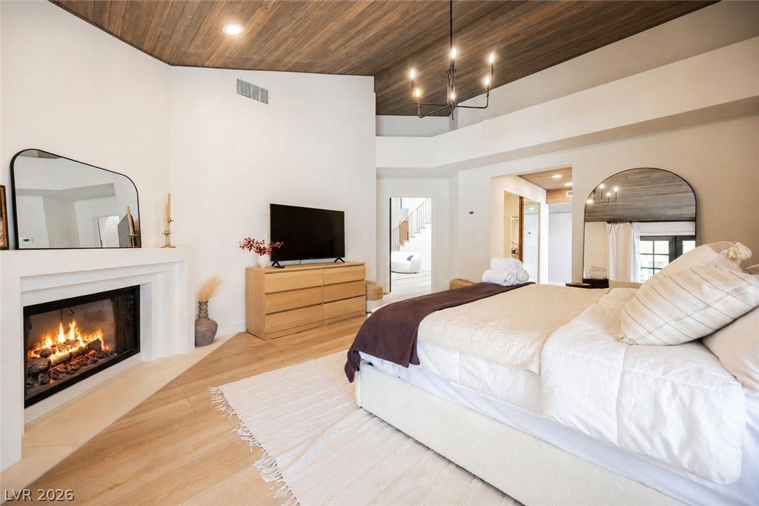 5741 S Pearl Street, Las Vegas, NV 89120 Rich wood plank ceilings and a cozy fireplace define this serene primary suite.